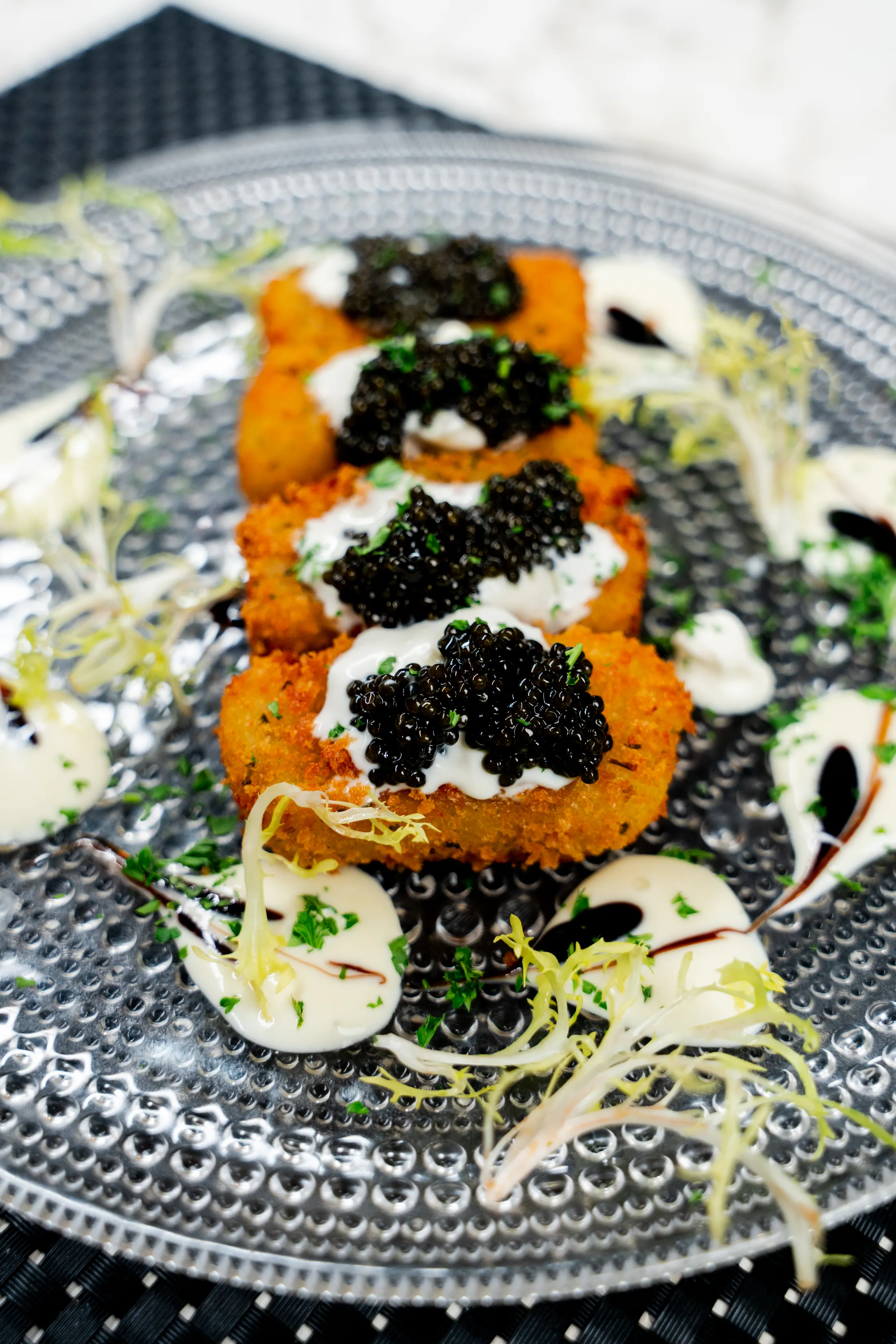 Tater tots caviar — crisp potato bites topped with caviar and crème fraîche
